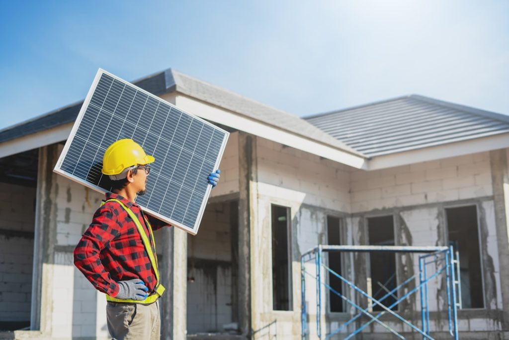 Asian construction worker holding metal sheet installation tool to build industrial factory roof.